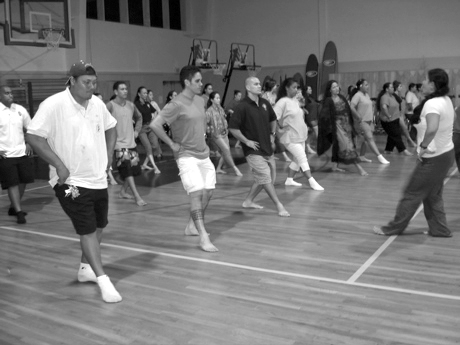 During a weekly language and culture class, parents of Nawahi students learn traditional Hawaiian dancing. 